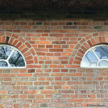 Der Überstand des Reetdaches schützt das Mauerwerk vor Durchfeuchtung. Das Mauerwerk – 1980 aufgeführt aus wiederverwendeten, historischen Steinen – zeigt intakte Oberflächen. In der unteren Zone, die dem Regen, der Luftfeuchte und den Westwinden ausgesetzt ist, entwickelt sich langsam Flechtenbewuchs, der jedoch Stein und Fuge nicht schädigt. Der Grauschleier überzieht beide Materialien gleichermaßen. Keine Ausbrüche der Backsteine durch Feuchte und Frost. Fuge und Stein weisen einen ähnlichen Härtegrad auf